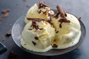 Vanilla ice cream scoops on dark plate